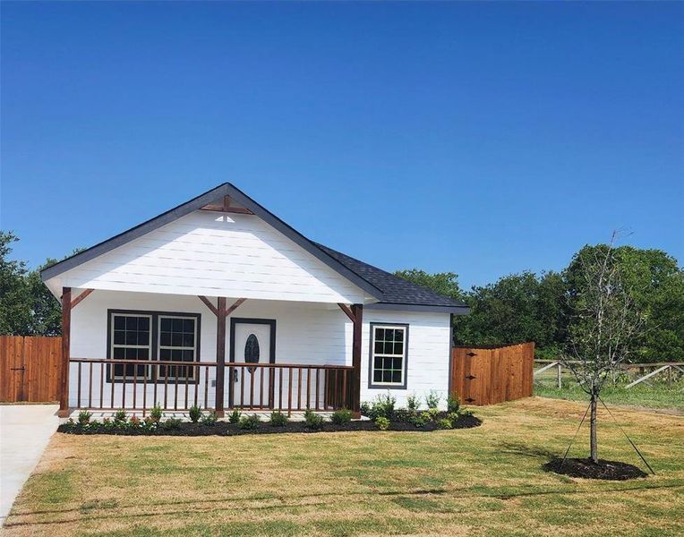 View of front facade with covered porch and a front lawn