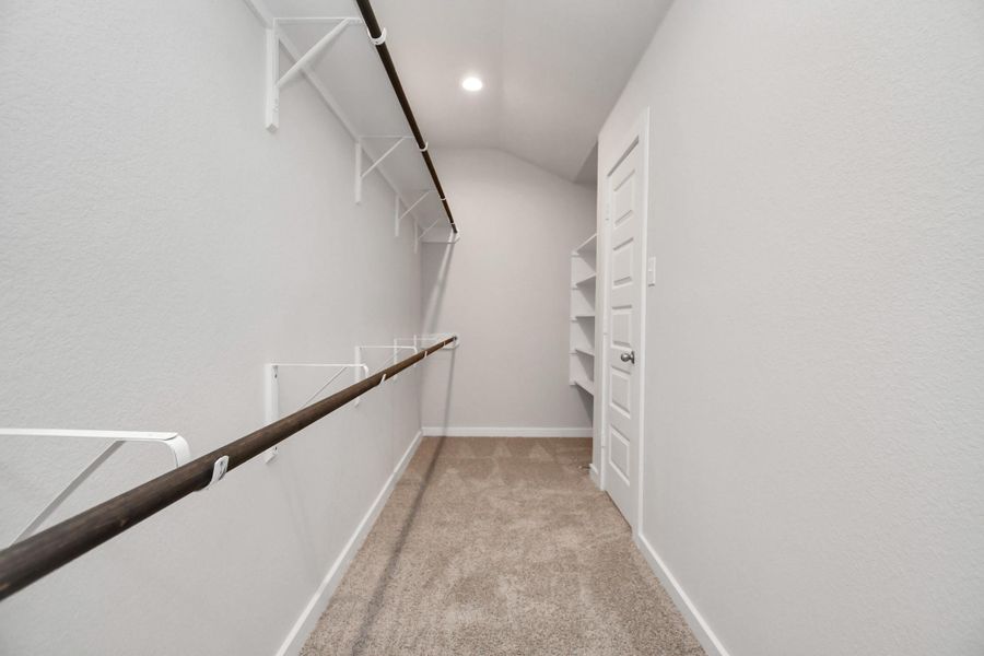 This generously sized walk in closet space boasts built-in shelving, providing ample room for organization. Sample photo of completed home with similar floor plan. Actual colors and selections may vary. This generously sized walk in closet space boasts built-in shelving, providing ample room for organization. Sample photo of completed home with similar floor plan. Actual colors and selections may vary.