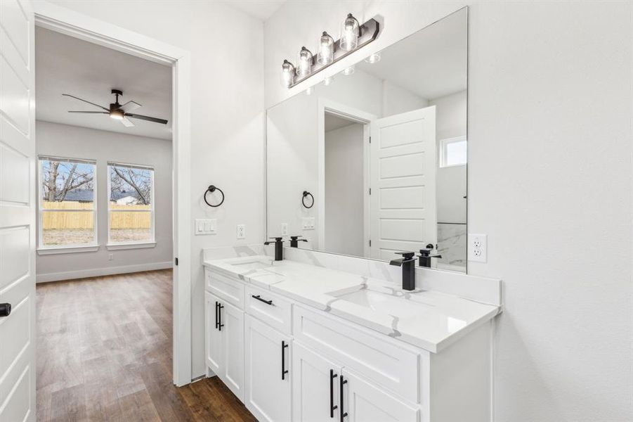 Bathroom with hardwood / wood-style flooring, vanity, and ceiling fan