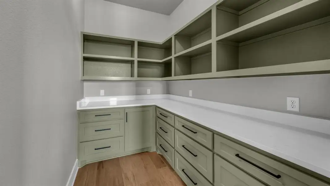 Custom cabinetry with a pale green finish and contrasting matte black hardware Custom cabinetry with a pale green finish and contrasting matte black hardware