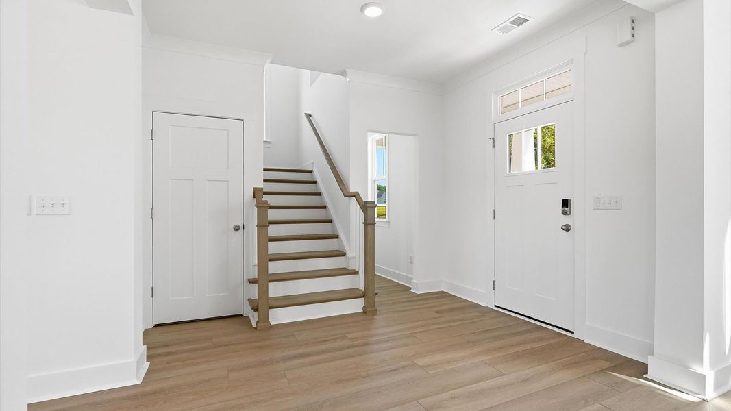 Notable hardwood flooring enhances the elegance of this accomplished entryway at the Pinebrook community