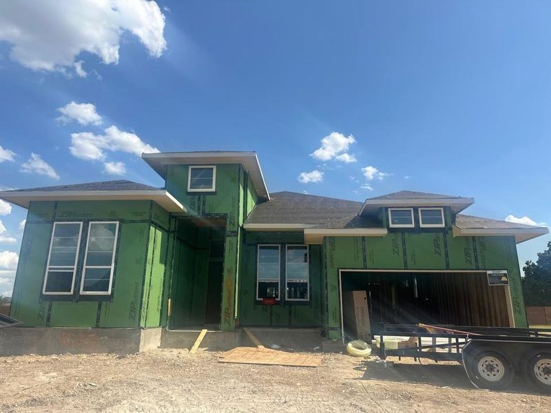 View of front of property with a garage and roof with shingles