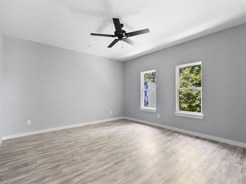 Unfurnished room with light wood-style flooring, baseboards, and ceiling fan