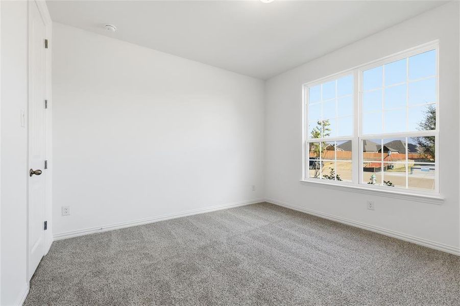 Carpeted spare room with baseboards