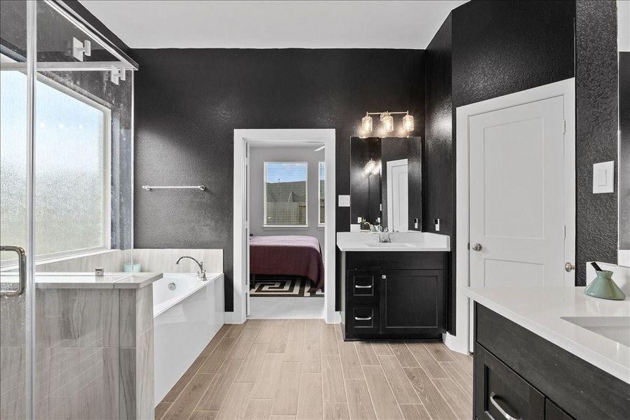 Designed with comfort and convenience in mind, the en suite features dual sinks with separated vanities, allowing each person their own dedicated space, along with two spacious walk-in closets. Designed with comfort and convenience in mind, the en suite features dual sinks with separated vanities, allowing each person their own dedicated space, along with two spacious walk-in closets.