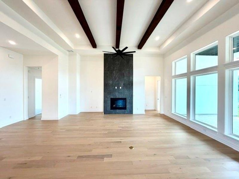 A spacious great room showcases soaring vaulted ceilings with exposed beams and a sleek, contemporary fireplace. A spacious great room showcases soaring vaulted ceilings with exposed beams and a sleek, contemporary fireplace.