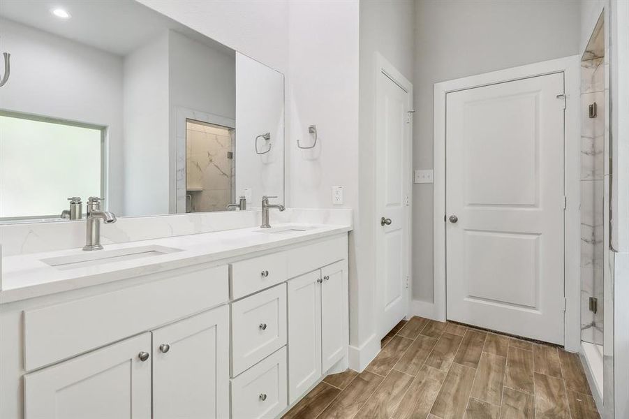 Bathroom featuring walk in shower, wood-type flooring, and vanity