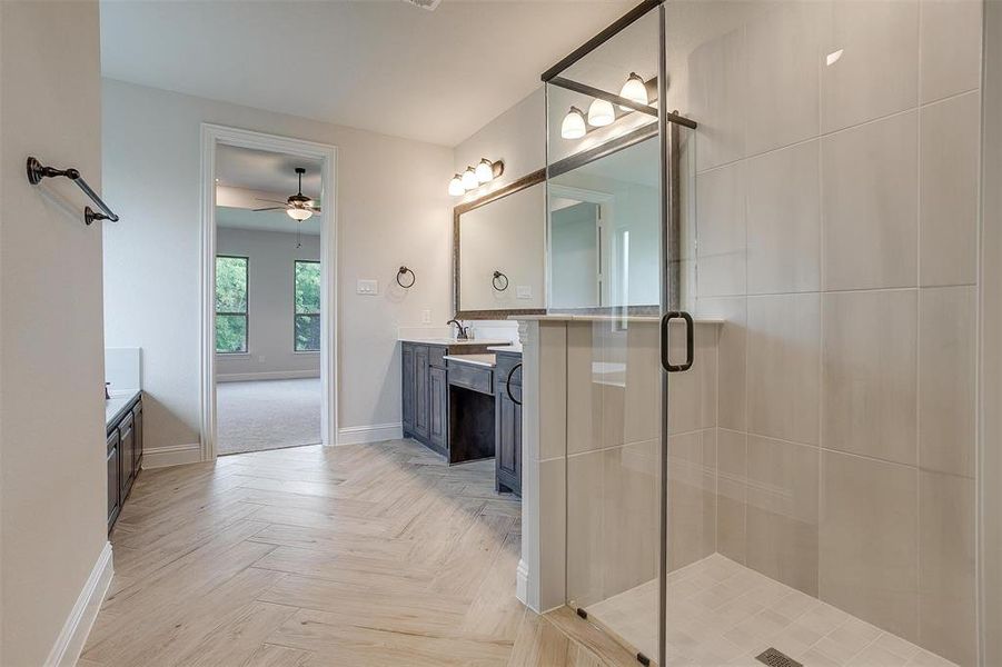 Bathroom featuring double sink vanity, ceiling fan, walk in shower, and parquet flooring