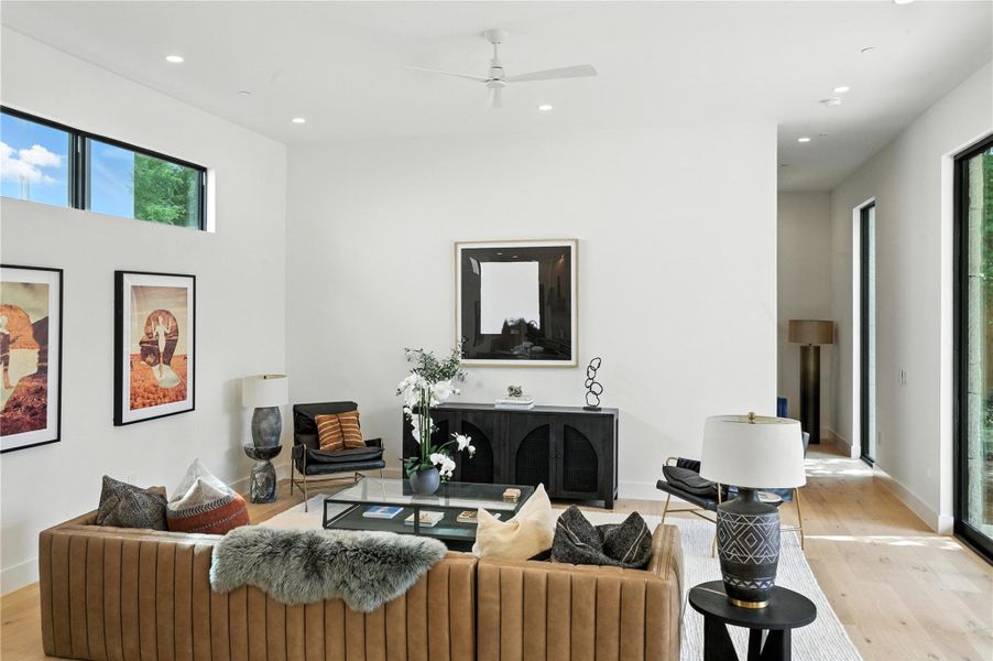 Living room featuring light wood-style flooring, healthy amount of natural light, recessed lighting, and a ceiling fan Living room featuring light wood-style flooring, healthy amount of natural light, recessed lighting, and a ceiling fan