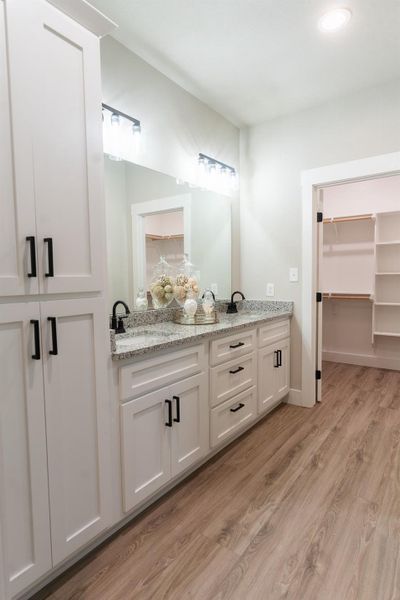 Bathroom with double vanity, wood finished floors, and recessed lighting