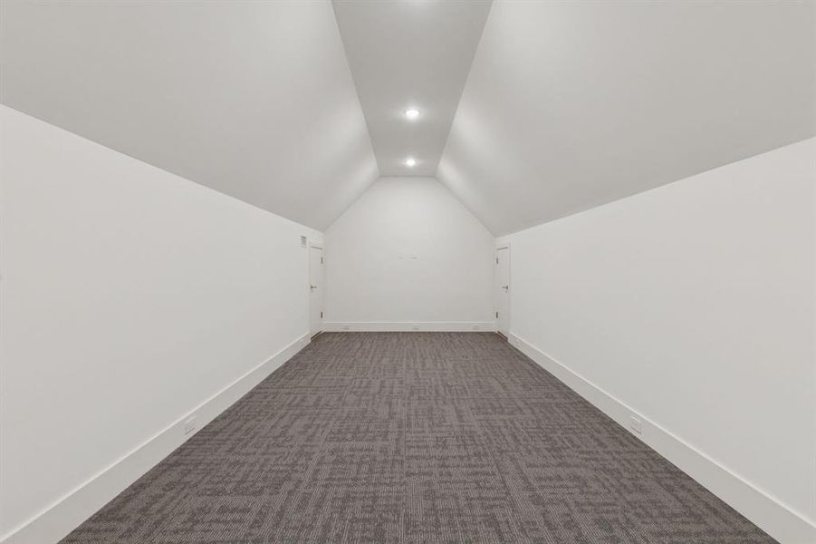 Additional living space featuring lofted ceiling, carpet flooring, and recessed lighting