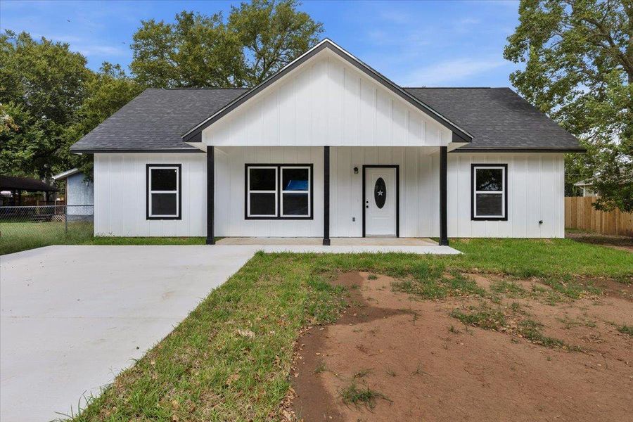 Crisp board and batten siding pairs with black trim on this modern ranch-style home. Crisp board and batten siding pairs with black trim on this modern ranch-style home.