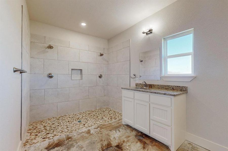 Bathroom featuring vanity and tiled shower