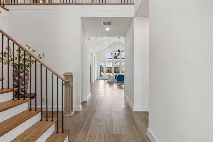 Corridor featuring high vaulted ceiling and light hardwood / wood-style flooring