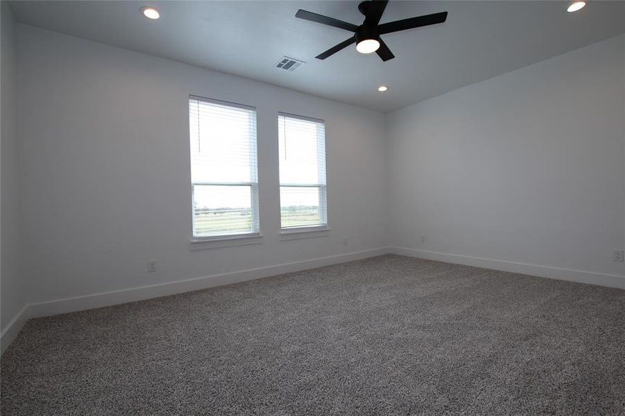 Carpeted spare room with a ceiling fan and recessed lighting Carpeted spare room with a ceiling fan and recessed lighting