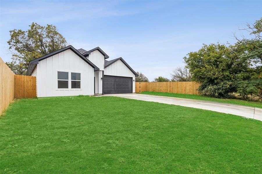 Modern farmhouse with a front lawn and a garage