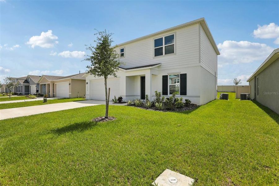 Front exterior of a new home in The Grove at Scenic Terrace, Lake Hamilton, FL, highlighting curb appeal (Image 21).