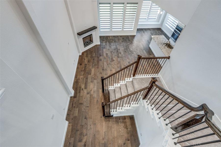 Stairs featuring hardwood / wood-style floors, a fireplace, and baseboards