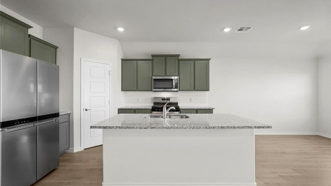 Kitchen island featuring a granite countertop with an undermount sink