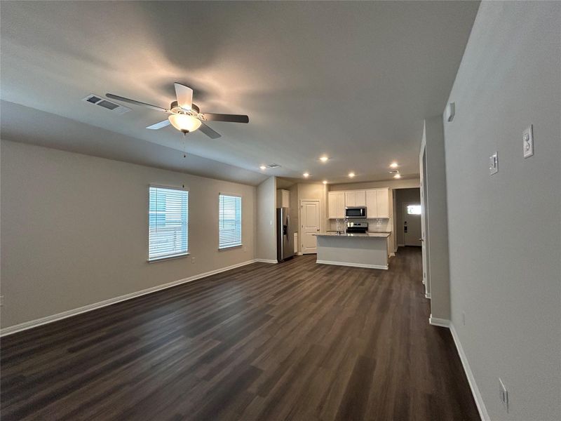 Unfurnished living room with recessed lighting, dark wood-style floors, and a ceiling fan Unfurnished living room with recessed lighting, dark wood-style floors, and a ceiling fan