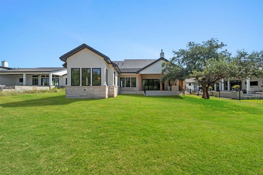 View of the back of the home. Main bedroom is on the left. Grass has been digitally edited as it grass was just recently added.