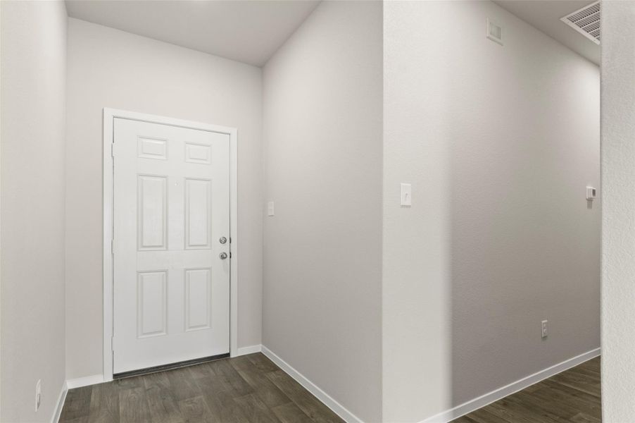 Foyer featuring dark wood-style flooring and baseboards