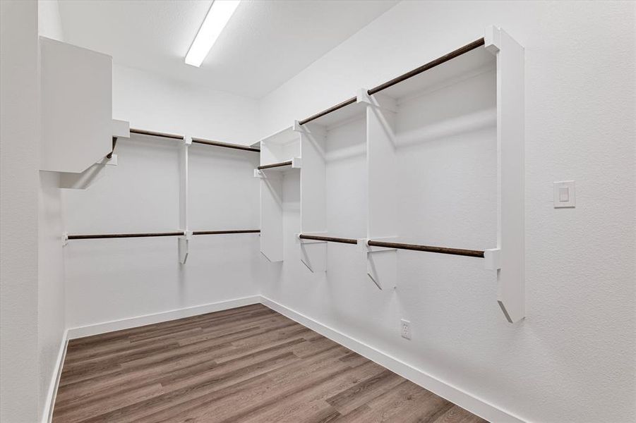 Walk in closet featuring hardwood / wood-style flooring Walk in closet featuring hardwood / wood-style flooring