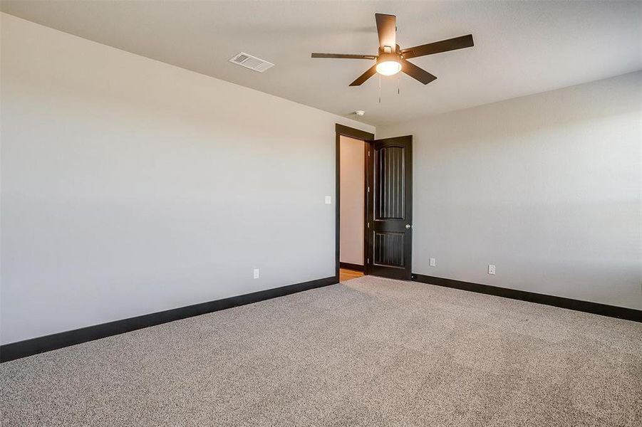 Carpeted empty room with ceiling fan