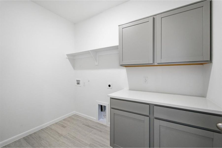 Laundry room with gas dryer hookup, electric dryer hookup, washer hookup, and cabinet space