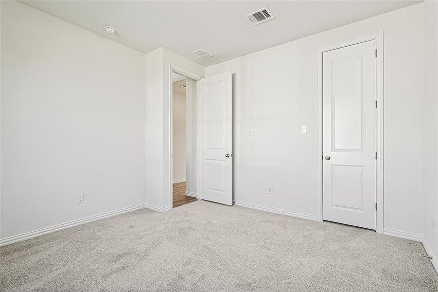 Unfurnished bedroom with carpet flooring Unfurnished bedroom with carpet flooring