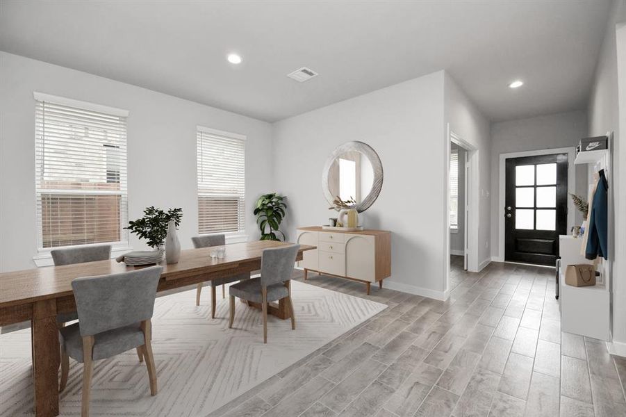 Craft enduring memories with loved ones around the table in this roomy dining area. It boasts stylish flooring, personalized paint, and is conveniently situated next to the family room and kitchen, fostering an open and inclusive ambiance. Sample photo of completed home with similar floor plan. Actual colors and selections may vary.