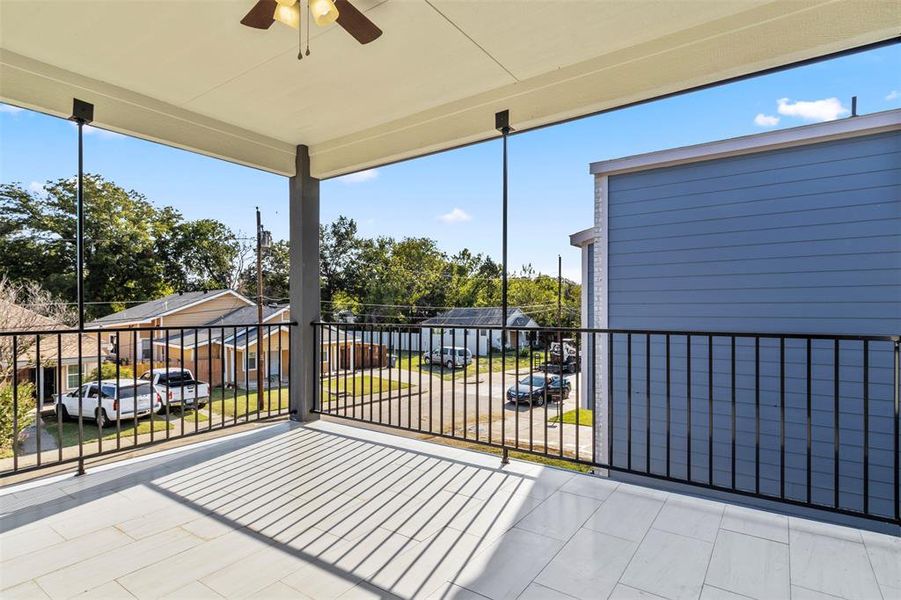 View of patio featuring ceiling fan and a balcony