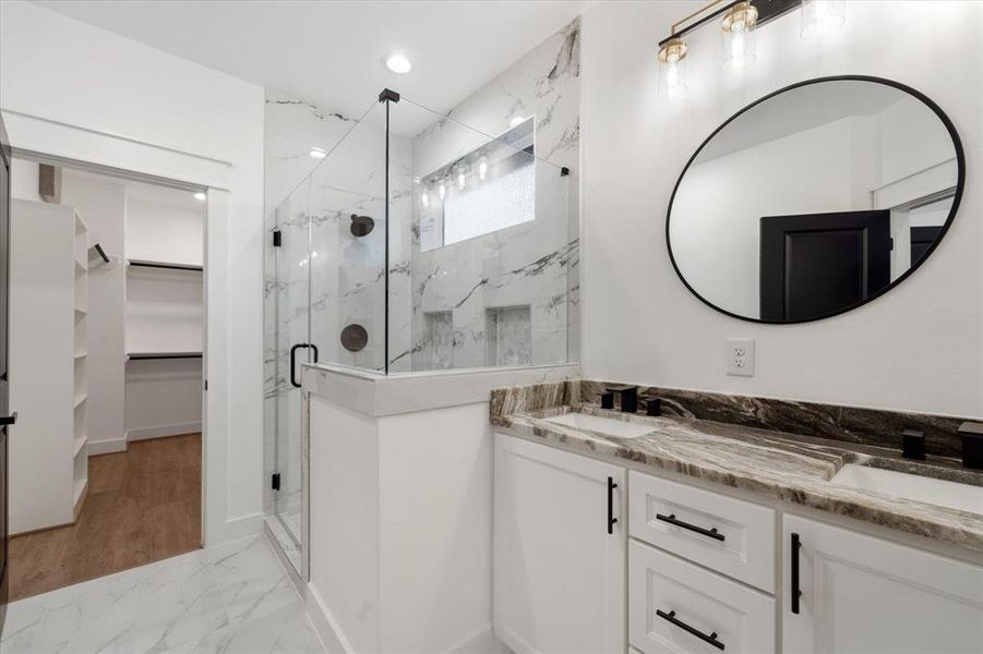 The primary bathroom has an elegant granite counter top, 2 under mount sinks and a gorgeous stand alone shower boasting a frameless glass door, floor to ceiling tile and two large soap niches.