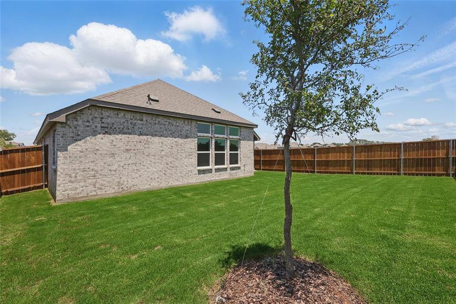 Back of property featuring brick siding and roof with shingles