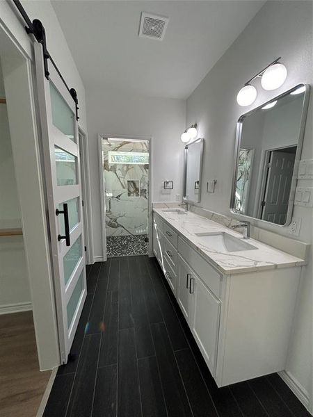 Bathroom featuring wood-type flooring, toilet, and an enclosed shower