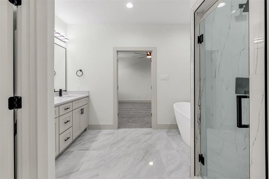 Full bathroom featuring a soaking tub, vanity, a marble finish shower, recessed lighting, and a ceiling fan
