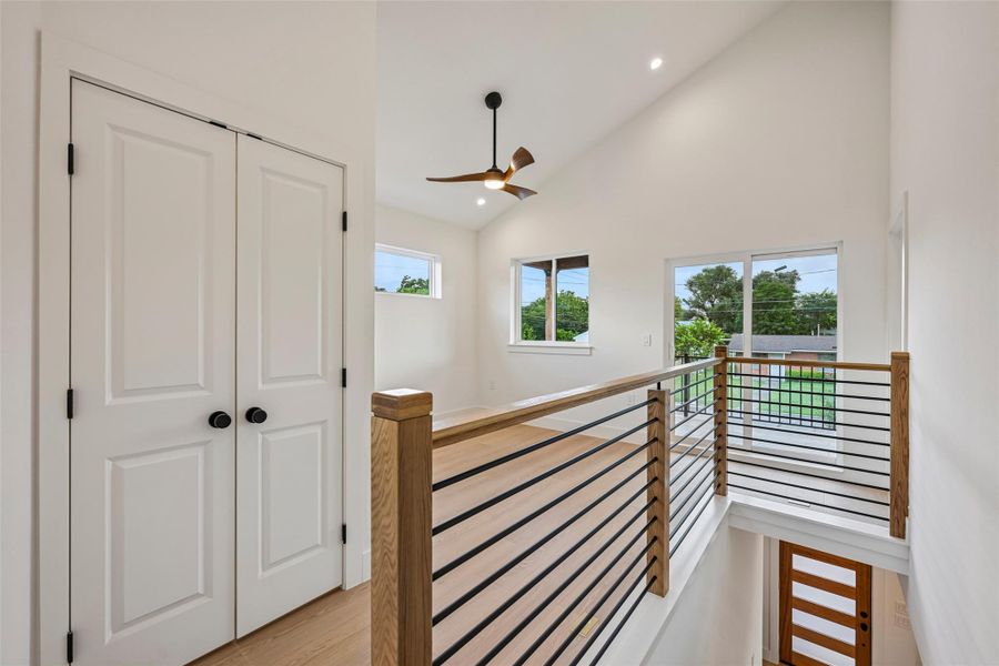Lofty ceilings and a sleek metal railing frame this bright, versatile upper-level space.