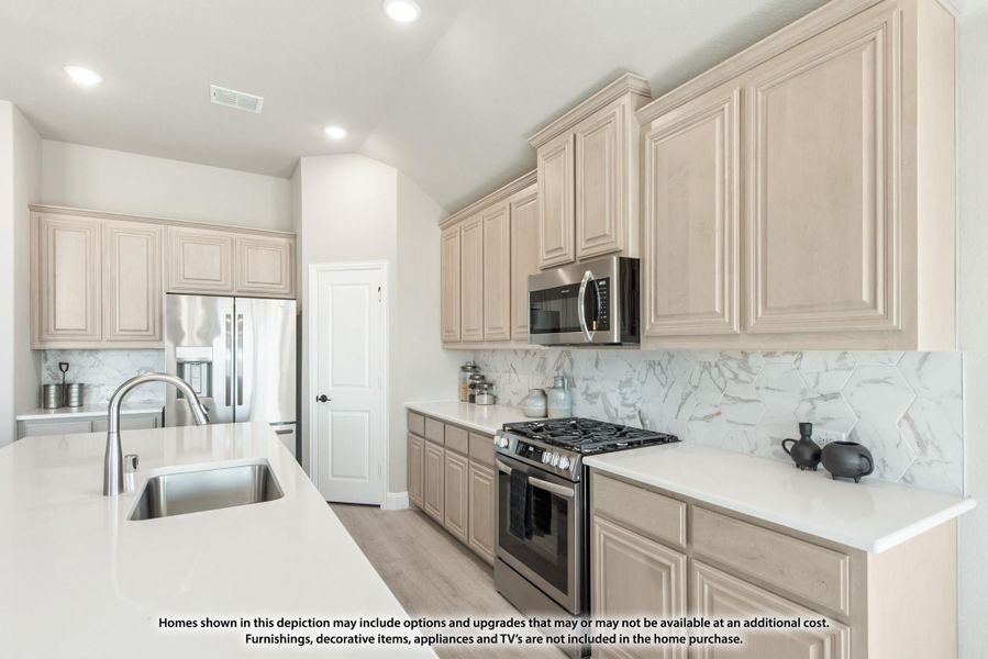 Kitchen with cream raised-panel cabinets, marble tile backsplash, white countertops, and stainless steel appliances Kitchen with cream raised-panel cabinets, marble tile backsplash, white countertops, and stainless steel appliances