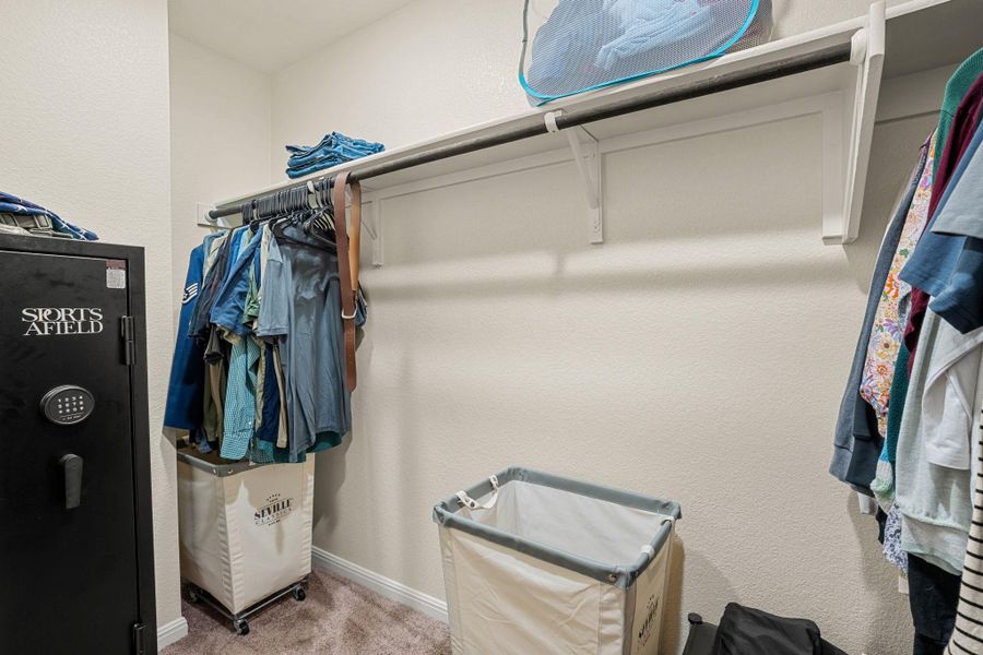 An organized walk-in closet provides ample storage with integrated shelving and hanging rods.