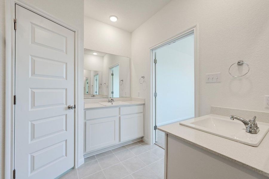 Dual vanities and sleek tile flooring outfit this well-appointed bathroom. Dual vanities and sleek tile flooring outfit this well-appointed bathroom.