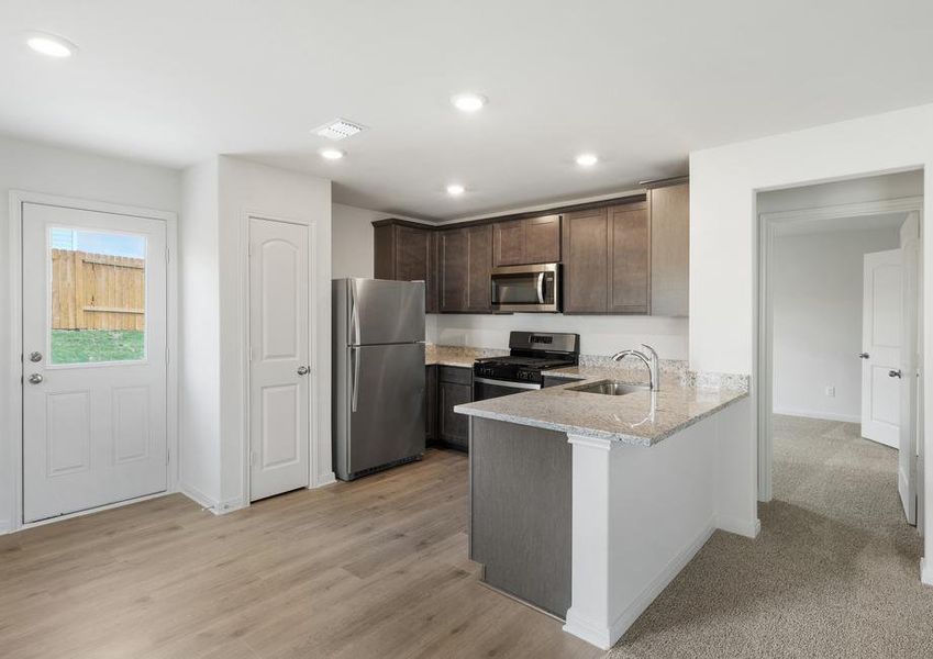 The kitchen has gorgeous wood cabinetry.