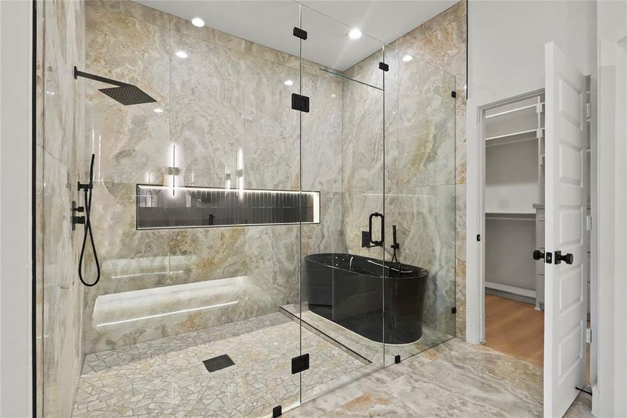 Bathroom featuring a walk in closet, a marble finish shower, marble tiled floors, and a soaking tub