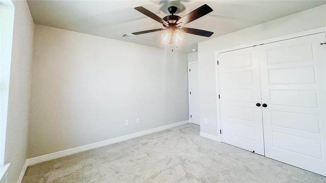 Unfurnished bedroom with carpet flooring, a closet, and ceiling fan Unfurnished bedroom with carpet flooring, a closet, and ceiling fan
