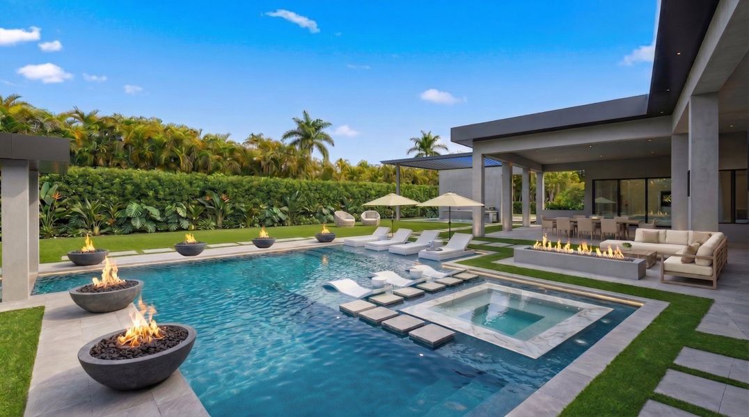 Heated saltwater pool with champagne style spa, 2,206 sqft. covered patio, pergola covered outdoor kitchen, accent fire bowls, artificial turf, and ample green space and landscaping.