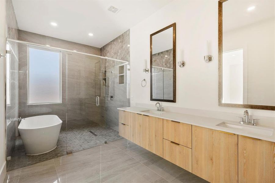 Bathroom featuring vanity and shower with separate bathtub