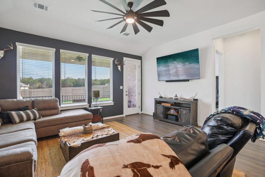 Living area with a ceiling fan, wood finished floors, and lofted ceiling Living area with a ceiling fan, wood finished floors, and lofted ceiling