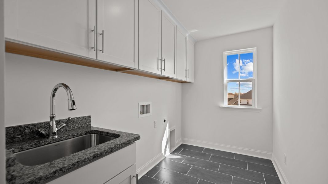 Burton Design laundry room with sink, extra cabinets, and premium finishes. By DRB Homes at Lakeside Glen in York, SC.