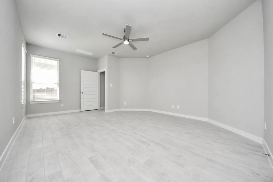 Come and unwind after a long day in this magnificent primary suite! This spacious room features beautiful flooring, warm paint, high ceilings and large windows with privacy blinds. Sample photo of completed home with similar floor plan. Actual colors and selections may vary.
