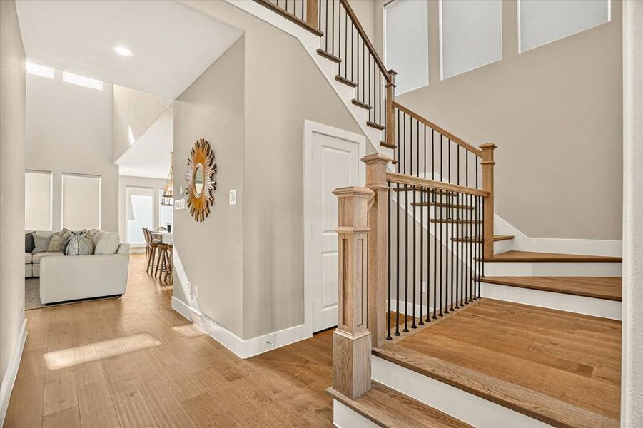 Staircase featuring wood-finish treads and risers, black metal balusters, and a wood-finish handrail Staircase featuring wood-finish treads and risers, black metal balusters, and a wood-finish handrail