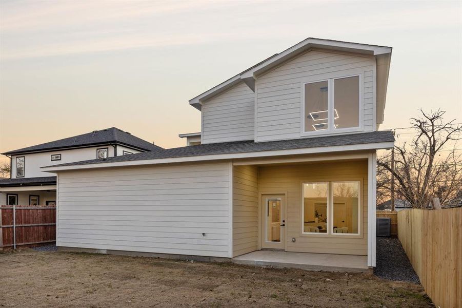 Back house at dusk featuring a patio